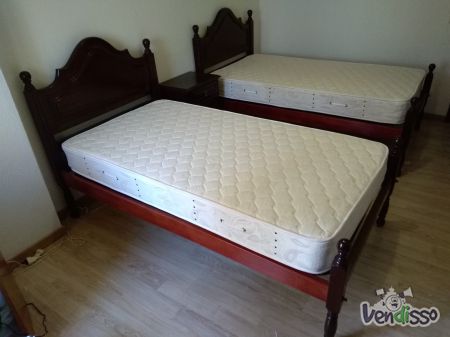 Camas de solteiro e mesa cabeceira